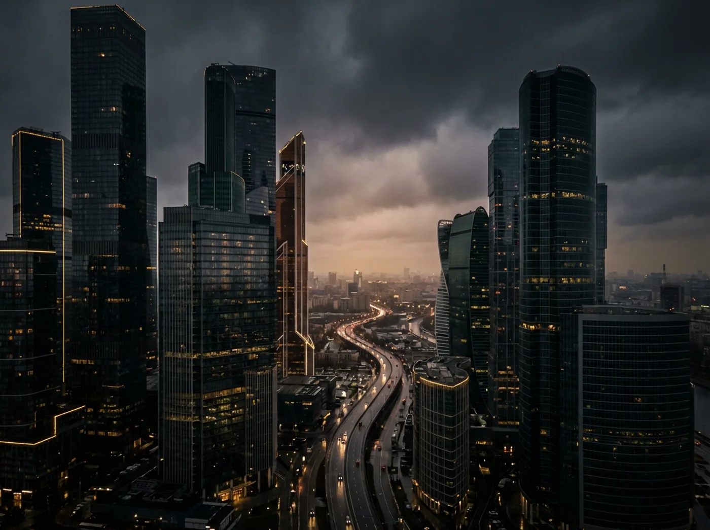 Contemporary towers and a winding city boulevard at dusk
